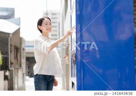 自販機でドリンクを買う女性 自販機でドリンクを買う女性 141643636