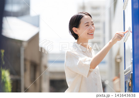 自販機でドリンクを買う女性 自販機でドリンクを買う女性 141643638