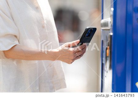 スマホでドリンクを買う女性の手元 スマホでドリンクを買う女性の手元 141643793