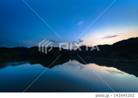 奈良県奈良市の布目ダム堰堤から南の布目湖夕景 超広角ズームレンズ 変わっていく夕焼け空⑫ 141645202