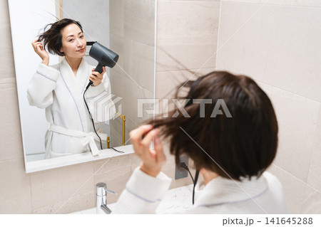 ドライヤーで髪を乾かしている女性　ビューティイメージ 141645288