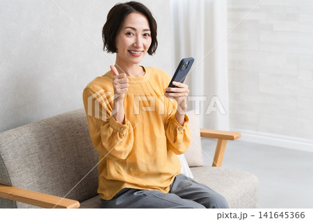 スマートフォンを操作する女性 ライフスタイルイメージ スマートフォンを操作する女性 ライフスタイルイメージ 141645366