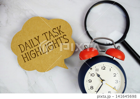 Daily Task Highlights text with magnifying glass and alarm clock on marble background 141645698