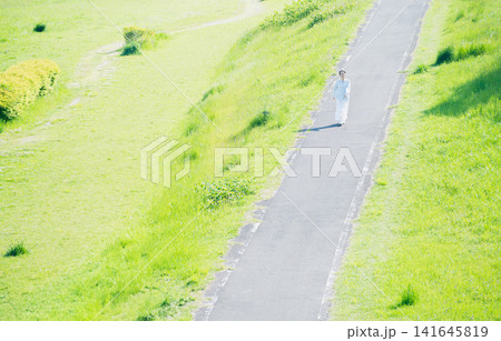散歩道を歩く若い女性 ライフスタイルイメージ 散歩道を歩く若い女性 ライフスタイルイメージ 141645819