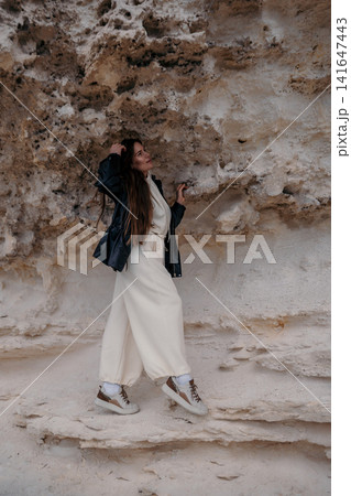 Woman cliffs travel Standing against a rugged limestone rock formation during an outdoor adventure with exploratory mood 141647443