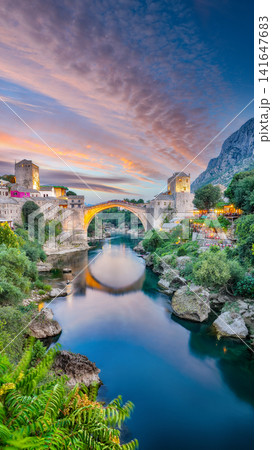 Amazing Skyline of Mostar with the Mostar Bridge, houses and minarets, at sunset. Amazing Skyline of Mostar with the Mostar Bridge, houses and minarets, at sunset. 141647683