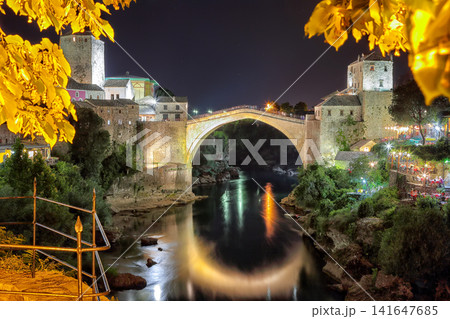 Amazing evening view of Mostar with the Mostar Bridge, houses and minarets, at evening. Amazing evening view of Mostar with the Mostar Bridge, houses and minarets, at evening. 141647685