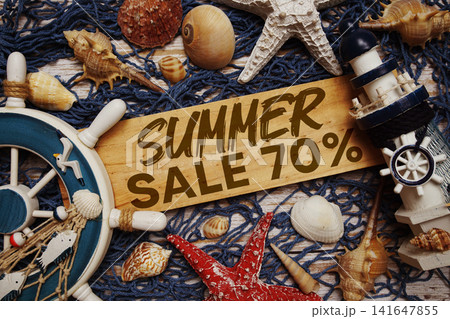 Summer Sale 70% off text on wooden sign decorated with marine nautical on a wooden background Summer Sale 70% off text on wooden sign decorated with marine nautical on a wooden background 141647855
