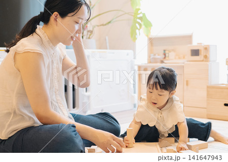 部屋の中で遊ぶ親子・子育てイメージ・つみきで遊ぶ女の子 部屋の中で遊ぶ親子・子育てイメージ・つみきで遊ぶ女の子 141647943