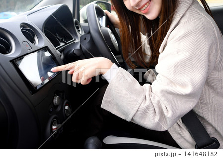 車内でカーナビを操作する若いアジア人女性 車内でカーナビを操作する若いアジア人女性 141648182