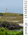 Lighthouse on Rugged Coastal Cliffs Overlooking Calm Sea Under Overcast Sky 141649152