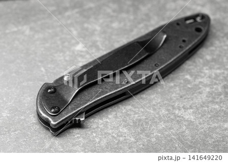 Closed folding pocket knife with pocket clip, macro photo Closed folding pocket knife with pocket clip, macro photo 141649220
