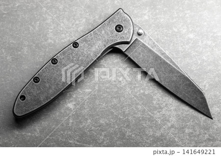 Close-up of a half opened folding pocket knife with a stonewashed blade Close-up of a half opened folding pocket knife with a stonewashed blade 141649221