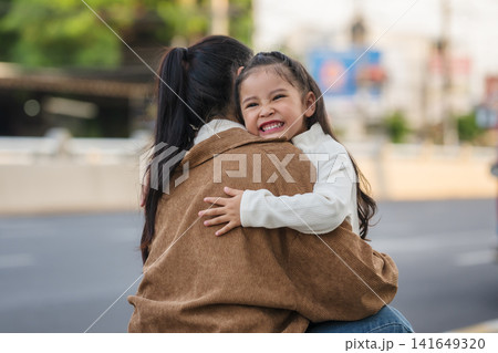 happy mother embracing daughter outdoors on city street happy mother embracing daughter outdoors on city street 141649320