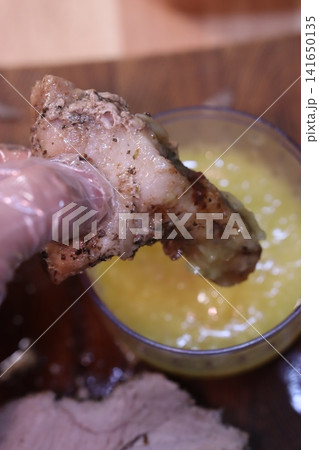 Dipping Seasoned Meat into Yellow Sauce Close-Up Dipping Seasoned Meat into Yellow Sauce Close-Up 141650135
