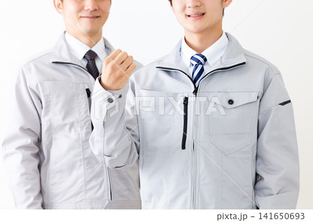 ガッツポーズする作業着を着た若い男性とミドル男性 ガッツポーズする作業着を着た若い男性とミドル男性 141650693