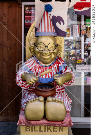 Billiken statue wearing party hat holding kushiage in shinsekai Osaka Billiken statue wearing party hat holding kushiage in shinsekai Osaka 141652017