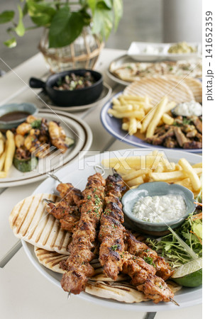 spicy marinated chicken skewer shish kebab mediterranean fusion meal on outdoor garden turkish restaurant table 141652359