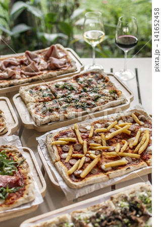 many different Pinsa types on garden restaurant pizza slice buffet table outdoors many different Pinsa types on garden restaurant pizza slice buffet table outdoors 141652458