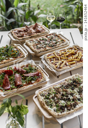 many different Pinsa types on garden restaurant pizza slice buffet table outdoors 141652464