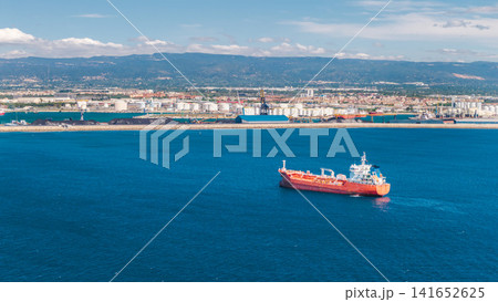 Aerial view of oil tanker sailing near industrial port and refinery facilities on Mediterranean coast in Tarragona Spain Aerial view of oil tanker sailing near industrial port and refinery facilities on Mediterranean coast in Tarragona Spain 141652625