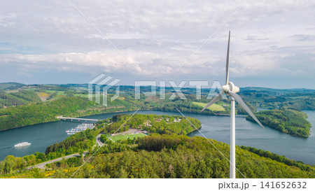 Aerial view of wind turbine above reservoir and forest landscape in Germany 141652632