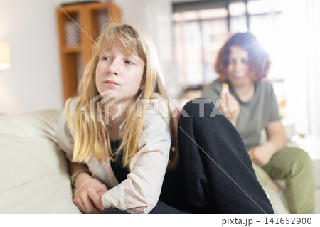 Teenage girl having conflict with blurred mother at home Teenage girl having conflict with blurred mother at home 141652900