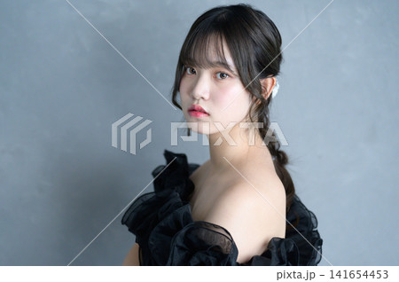 グレー背景で黒いドレスを着た日本人女性 グレー背景で黒いドレスを着た日本人女性 141654453