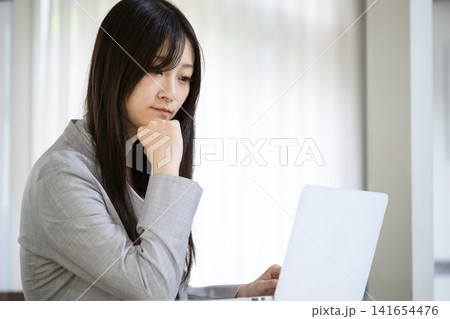 ノートパソコンの前で考える日本人女性 ノートパソコンの前で考える日本人女性 141654476