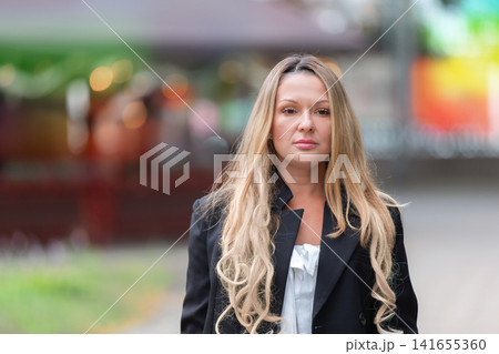 Confident woman walking in urban setting during day, showcasing fashion and style Confident woman walking in urban setting during day, showcasing fashion and style 141655360