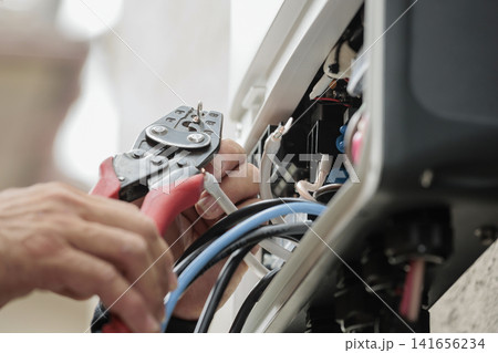 分電盤内で圧着工具を使い端子に電線を接続する様子 分電盤内で圧着工具を使い端子に電線を接続する様子 141656234