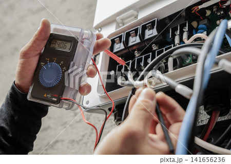 テスターで電圧を測定する電気工事士の手元 テスターで電圧を測定する電気工事士の手元 141656236