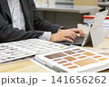 建材サンプルを前にタブレットへ入力する内装設計士の手元 141656262