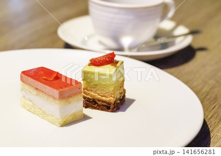 温かいホットコーヒーと奥に見えるスイーツプレート 温かいホットコーヒーと奥に見えるスイーツプレート 141656281