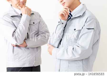 悩む作業着を着た若い男性とミドル男性 141656583