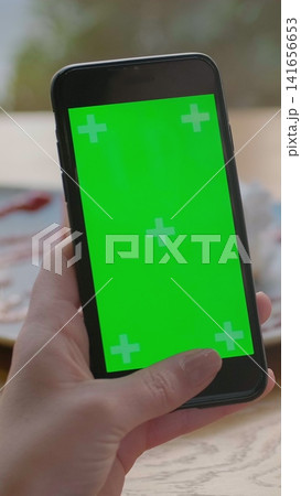 Vertical video. Businesswoman using mobile cell phone with green touch screen in cafe. Green Screen. 141656653