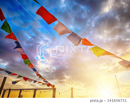 Colorful prayer flags against dramatic sunset sky in The Hague, Netherlands Colorful prayer flags against dramatic sunset sky in The Hague, Netherlands 141656731