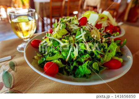 Greek salad with white wine in a traditional restaurant Greek salad with white wine in a traditional restaurant 141656850