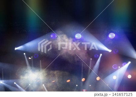 Colorful stage lights illuminating a vibrant performance at a music festival in the evening Colorful stage lights illuminating a vibrant performance at a music festival in the evening 141657125