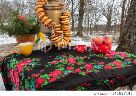 Decorative table setup in the woods with traditional items and snacks during winter 141657143
