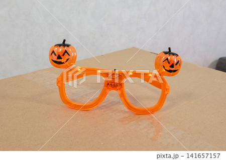 Bright orange glasses with pumpkin decorations for Halloween celebration on a plain background Bright orange glasses with pumpkin decorations for Halloween celebration on a plain background 141657157