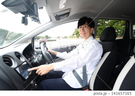 車内でカーナビを操作する若いアジア人男性 車内でカーナビを操作する若いアジア人男性 141657165