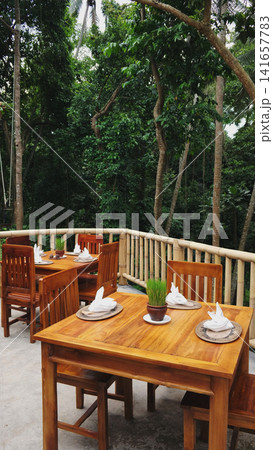 Wooden tables set up in an outdoor cafe against the background of a tropical jungle Wooden tables set up in an outdoor cafe against the background of a tropical jungle 141657783