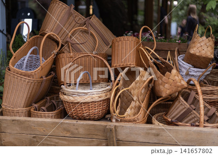 Collection of woven wicker baskets on a wooden display Collection of woven wicker baskets on a wooden display 141657802