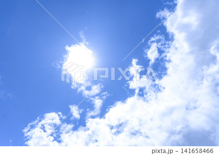 8月上旬の夏空 太陽と白い雲の青空背景 8月上旬の夏空 太陽と白い雲の青空背景 141658466