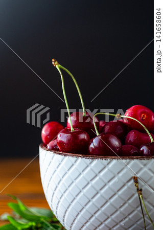 Healthy summer cherries with fresh mint on rustic table Healthy summer cherries with fresh mint on rustic table 141658604