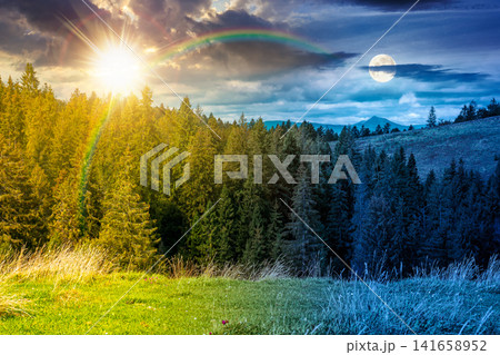 nature scenery with coniferous forest in mountain. day meet night. sun and moon over carpathian landscape with spruce woodland on the hill at twilight. ukraine nature background on autumn equinox nature scenery with coniferous forest in mountain. day meet night. sun and moon over carpathian landscape with spruce woodland on the hill at twilight. ukraine nature background on autumn equinox 141658952