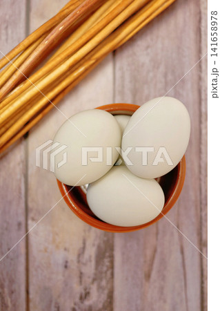 Fresh duck eggs in clay bowl on rustic wooden table. Organic farm produce, healthy natural food ingredient for cooking, baking and nutritious meals. Fresh duck eggs in clay bowl on rustic wooden table. Organic farm produce, healthy natural food ingredient for cooking, baking and nutritious meals. 141658978