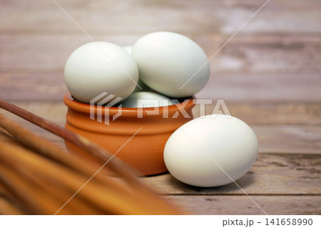 Fresh duck eggs in clay bowl on rustic wooden table. Organic farm produce, healthy natural food ingredient for cooking, baking and nutritious meals. 141658990
