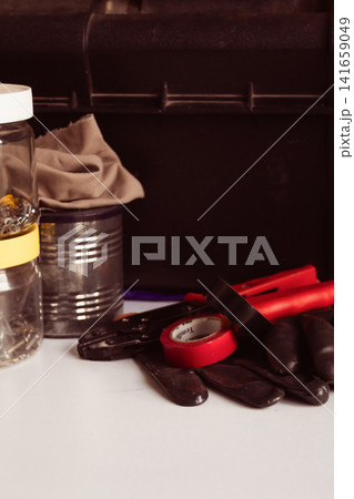 Tools and equipment such as work gloves, insulating tape and pliers, ready for various tasks, symbolize work and craftsmanship. Tools and equipment such as work gloves, insulating tape and pliers, ready for various tasks, symbolize work and craftsmanship. 141659049